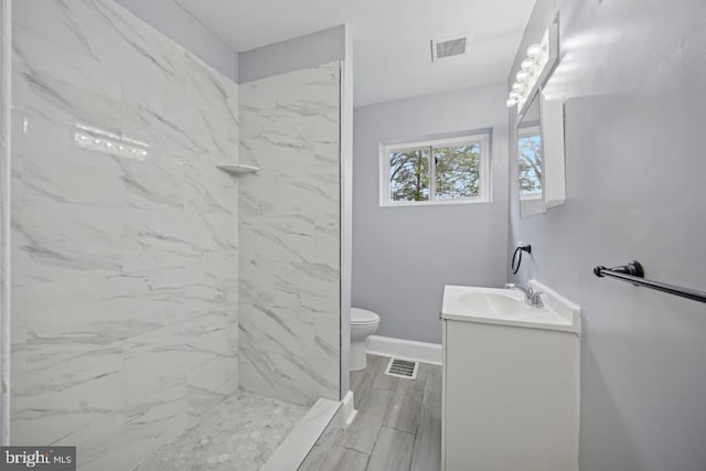 full bathroom featuring vanity, toilet, a shower, and visible vents