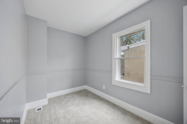 empty room with baseboards, visible vents, and carpet
