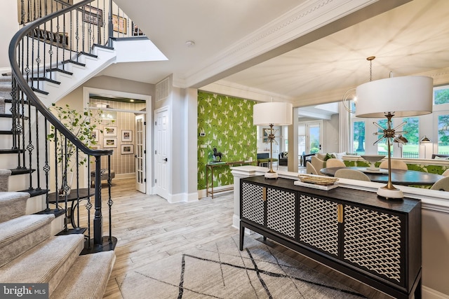 living area with stairway, light wood-type flooring, ornamental molding, and baseboards