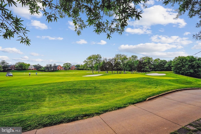 surrounding community featuring view of golf course and a lawn
