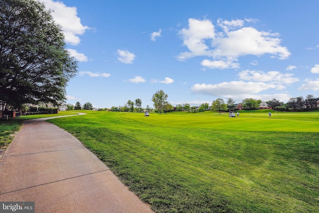 view of home's community featuring golf course view and a yard