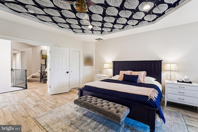bedroom featuring wood finished floors and a raised ceiling