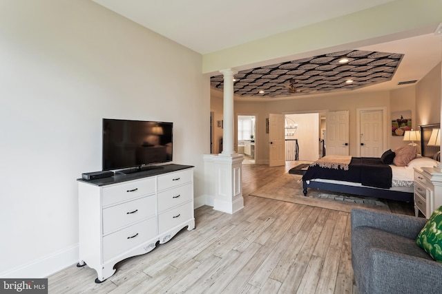 living area with decorative columns, baseboards, and light wood-style flooring