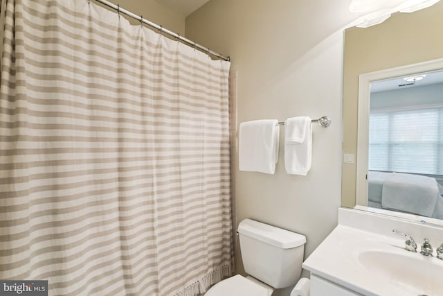 full bathroom featuring vanity, toilet, and curtained shower