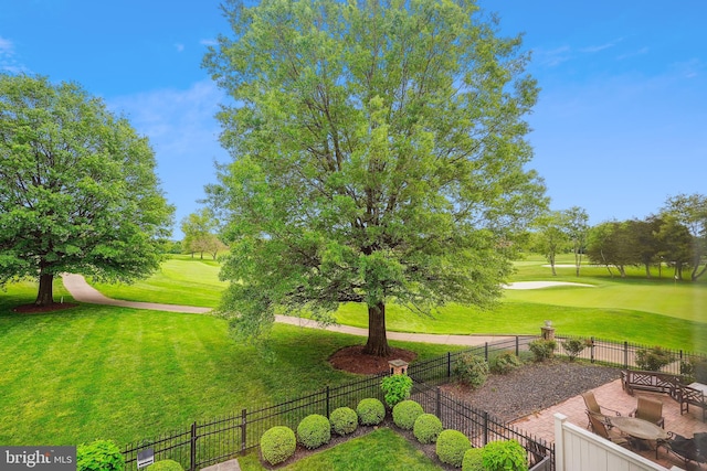 view of property's community featuring view of golf course and a patio area