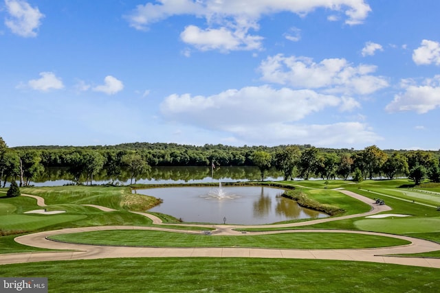 view of home's community with a water view, a lawn, and view of golf course