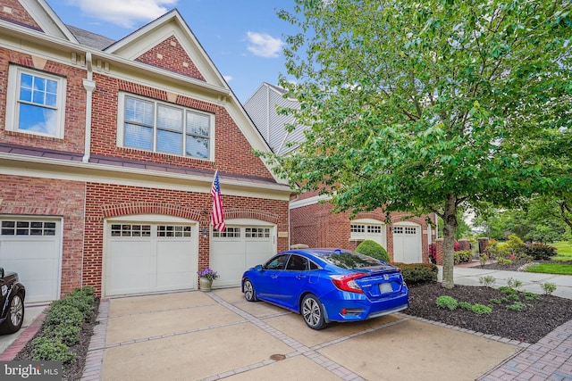 view of front of house with driveway, a garage, and brick siding