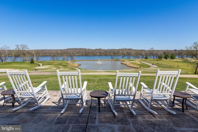 view of patio featuring a water view, a fire pit, and golf course view