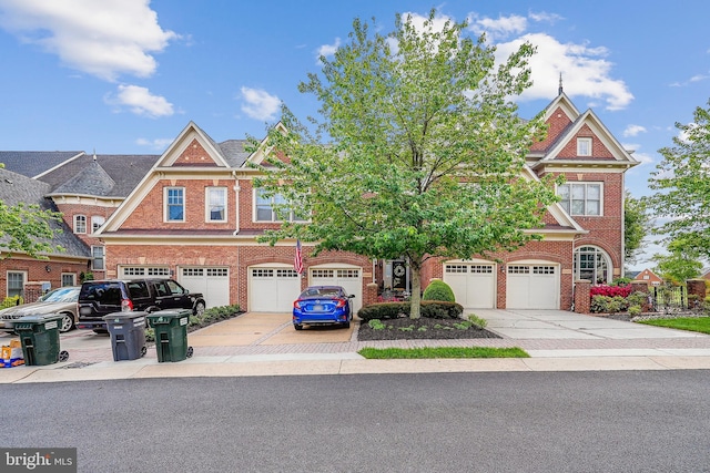 colonial inspired home featuring a garage, driveway, and brick siding