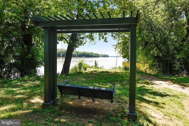 view of property's community with a water view and a lawn