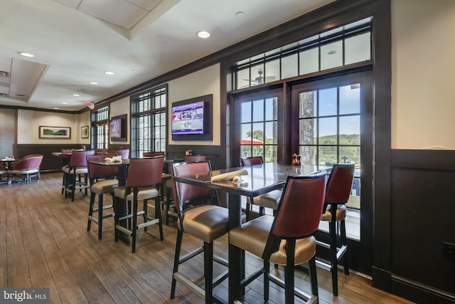 dining room with plenty of natural light, wood finished floors, ornamental molding, and recessed lighting