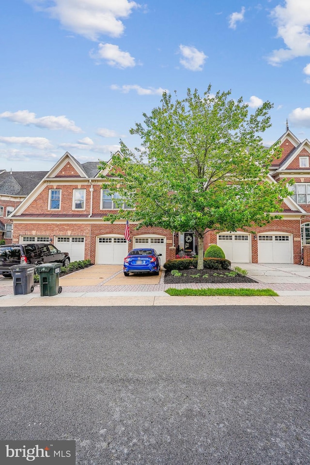 view of property with brick siding, driveway, and an attached garage