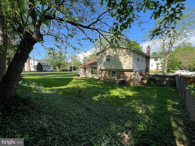 view of yard with fence and central AC