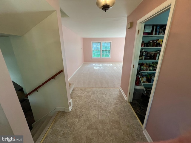 hallway featuring baseboards and an upstairs landing