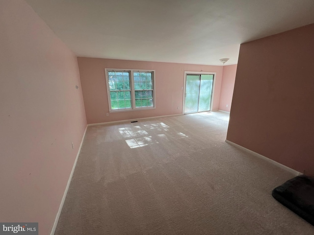 spare room featuring carpet, baseboards, and visible vents