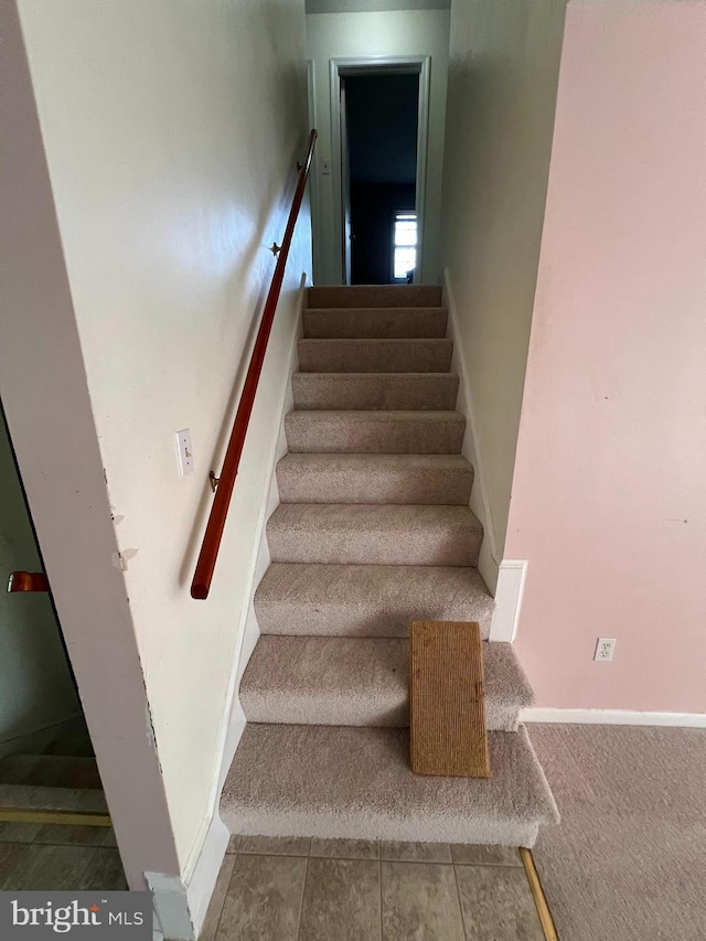staircase featuring baseboards