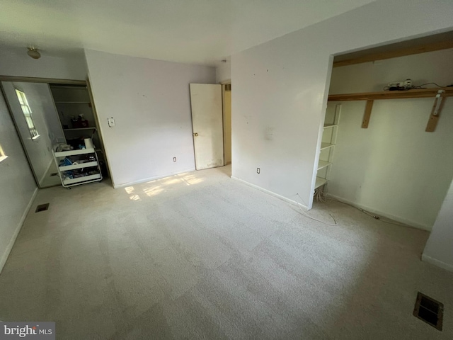 unfurnished bedroom with a closet, visible vents, baseboards, and carpet floors