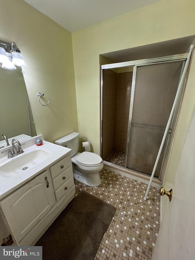 full bathroom with a shower stall, tile patterned floors, vanity, and toilet