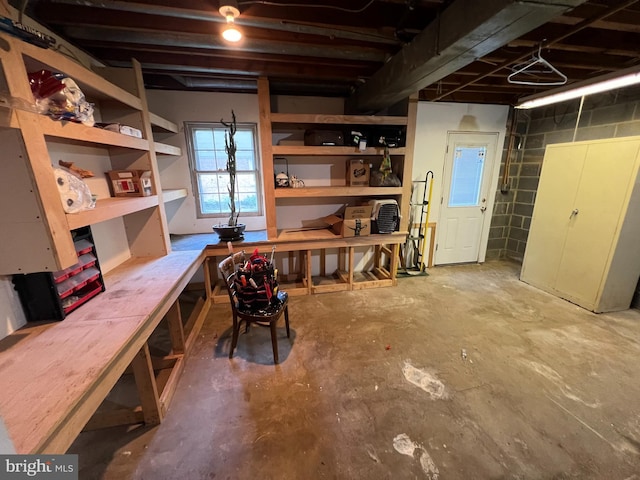 basement featuring a workshop area and concrete block wall