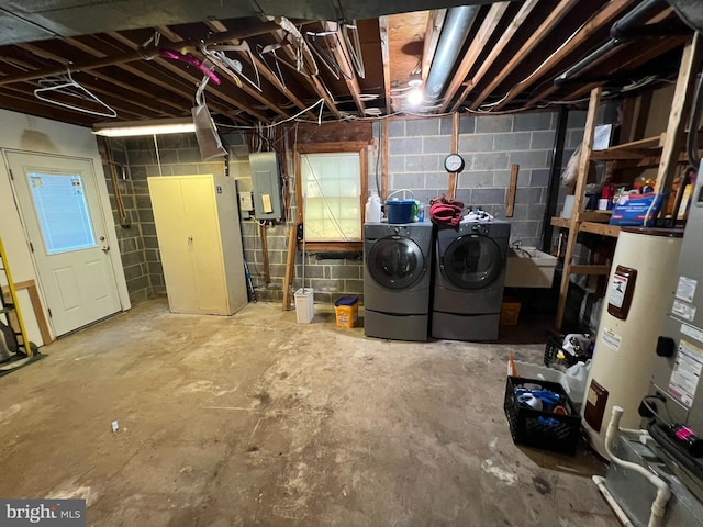 unfinished below grade area with electric panel, water heater, washer and clothes dryer, and concrete block wall