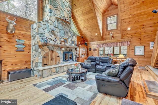 living area with high vaulted ceiling, a wealth of natural light, and wood-type flooring