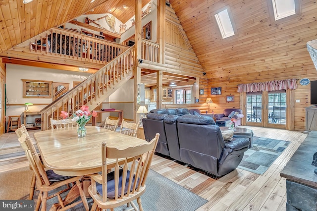 dining space featuring high vaulted ceiling, wood finished floors, stairway, and wooden ceiling