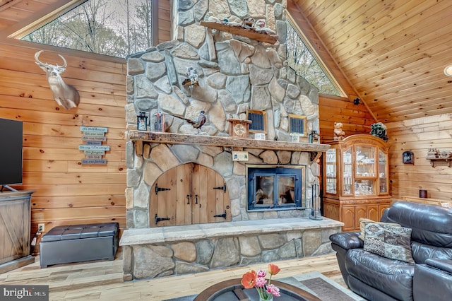 living room with a healthy amount of sunlight, wooden ceiling, wooden walls, a fireplace, and wood finished floors