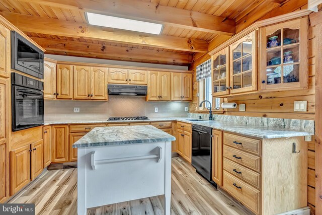 kitchen featuring light wood finished floors, a sink, under cabinet range hood, black appliances, and wood ceiling