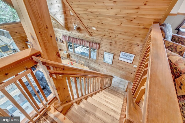 stairway with wood walls and wood ceiling
