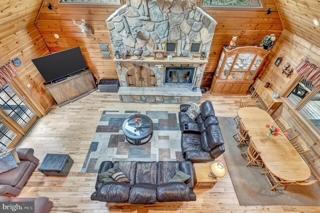 living room with wooden walls, hardwood / wood-style floors, and plenty of natural light