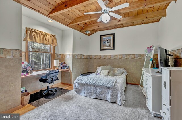 bedroom with lofted ceiling with beams, a ceiling fan, wood ceiling, wainscoting, and carpet floors