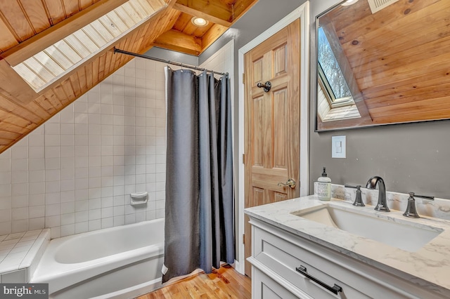 full bath with vaulted ceiling with skylight, shower / tub combo with curtain, wooden ceiling, wood finished floors, and vanity