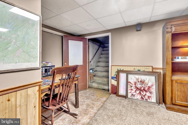 office featuring light tile patterned floors, a wainscoted wall, and a paneled ceiling