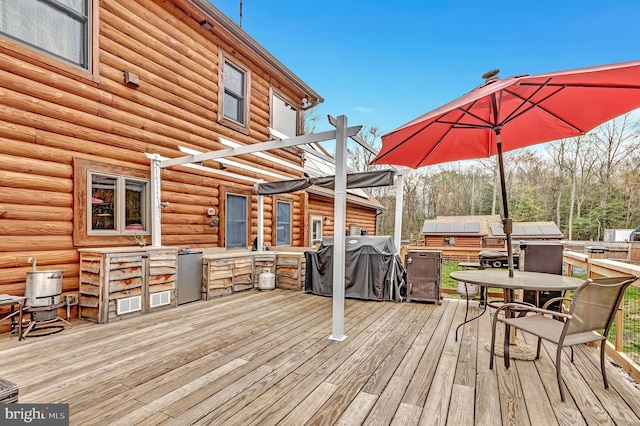 wooden terrace with area for grilling and outdoor dining area