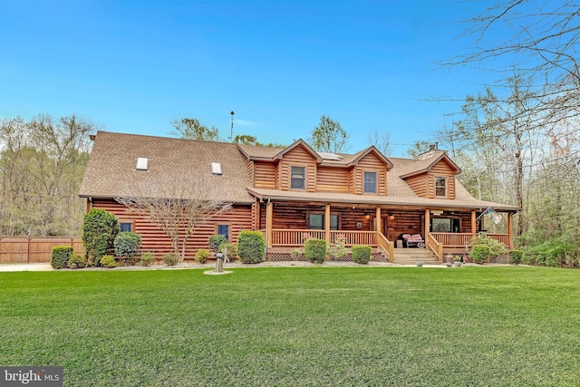 cabin featuring log siding, a front yard, and a shingled roof