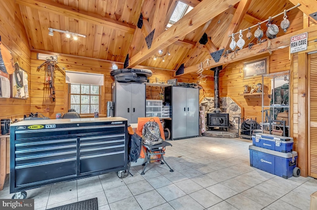 miscellaneous room featuring a wood stove, beam ceiling, tile patterned floors, wood walls, and wood ceiling