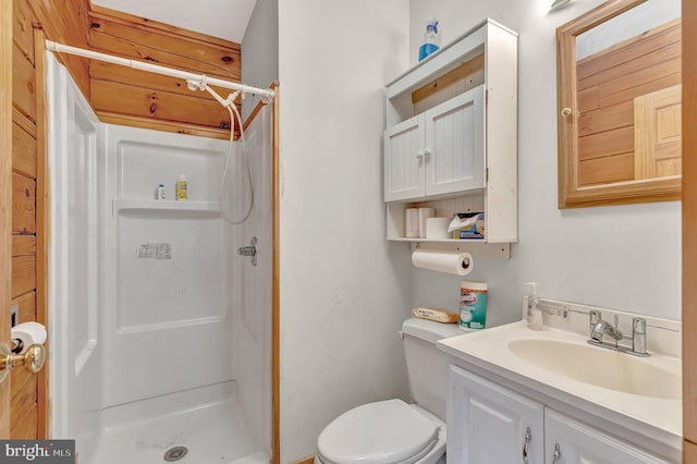 bathroom with toilet, a stall shower, and vanity