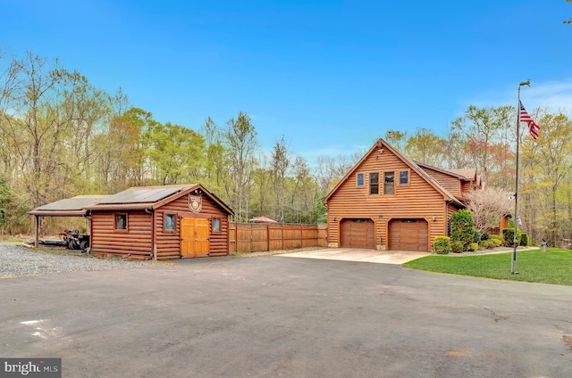 view of front of home with fence, aphalt driveway, metal roof, and an attached garage