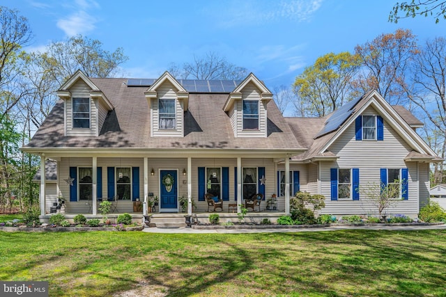 cape cod home with a front yard, a porch, and solar panels