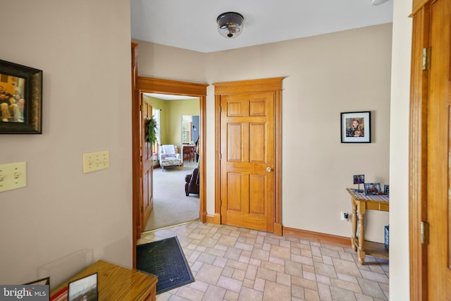 foyer featuring stone finish flooring and baseboards