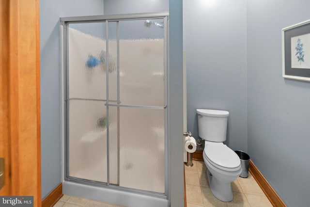 full bath with tile patterned floors, baseboards, a shower stall, and toilet