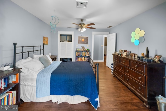 bedroom with a closet, visible vents, a ceiling fan, and wood finished floors