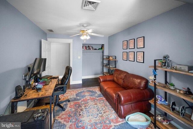 home office with baseboards, visible vents, wood finished floors, and ceiling fan