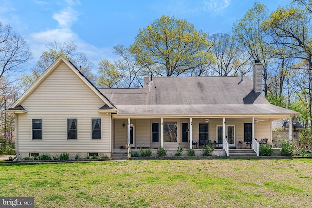 view of front facade featuring covered porch, a front yard, and a chimney