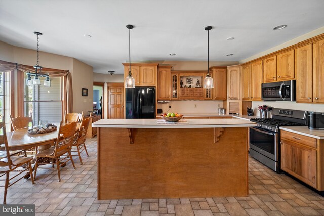 kitchen featuring a center island, glass insert cabinets, appliances with stainless steel finishes, and light countertops