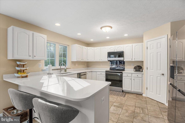 6815 Interlude Pl, Hughesville, MD 20637 - kitchen with a kitchen breakfast bar, white cabinets, a sink, stainless steel appliances, and a peninsula