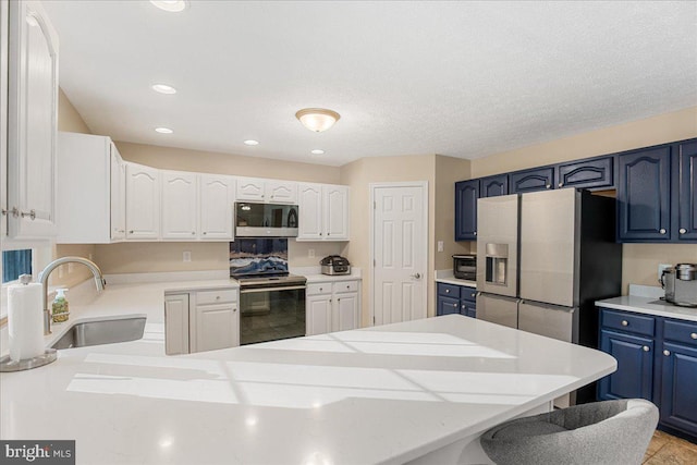 6815 Interlude Pl, Hughesville, MD 20637 - kitchen with a sink, appliances with stainless steel finishes, light countertops, blue cabinetry, and a peninsula
