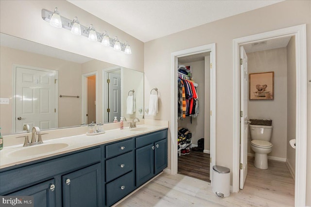 6815 Interlude Pl, Hughesville, MD 20637 - bathroom with toilet, double vanity, a sink, and wood finished floors
