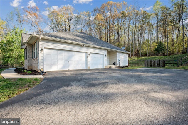6815 Interlude Pl, Hughesville, MD 20637 - view of property exterior featuring fence, brick siding, aphalt driveway, and an attached garage