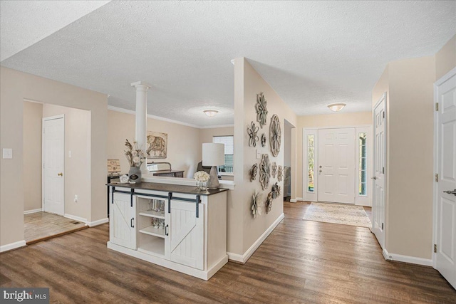 6815 Interlude Pl, Hughesville, MD 20637 - entryway with a textured ceiling, baseboards, ornate columns, and dark wood-type flooring